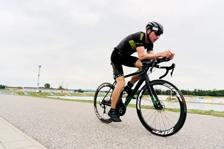 Cyclist in aero position beside the canal